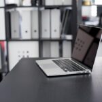 Laptop ouvert sur bureaux moderne avec étagères de rangement en arrière-plan