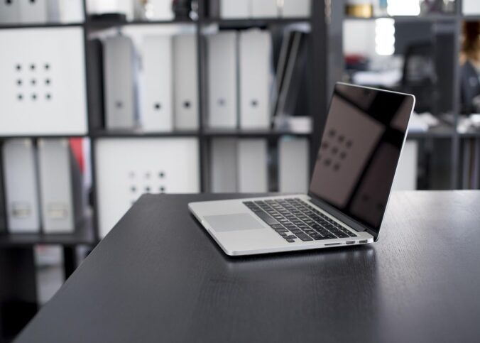 Laptop ouvert sur bureaux moderne avec étagères de rangement en arrière-plan