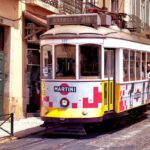 Un tramway ancien coloré circule dans une rue pavée animée