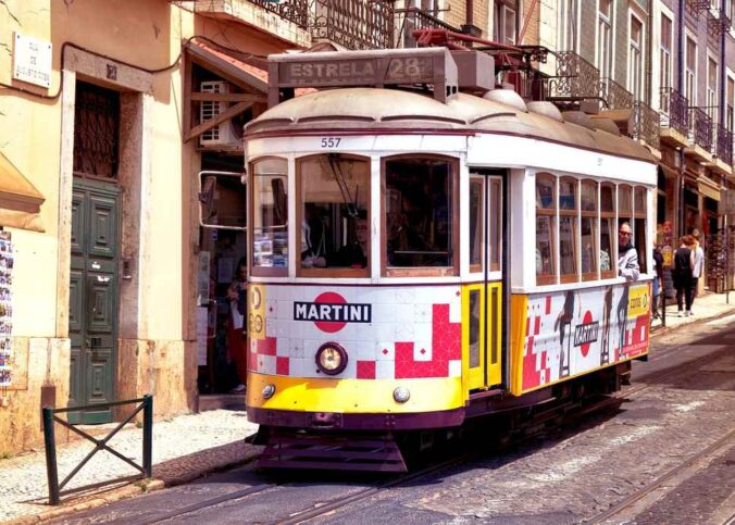 Un tramway ancien coloré circule dans une rue pavée animée