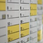 Calendrier mural avec dates, jours et cases jaunes sur tableau