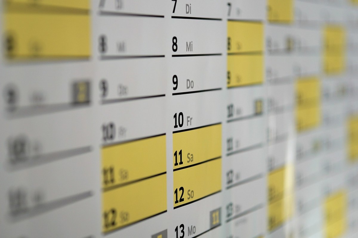 Calendrier mural avec dates, jours et cases jaunes sur tableau